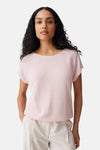 Top rose à manches courtes de OPUS, tricoté, encolure ronde et manches raglan, porté avec un pantalon clair.