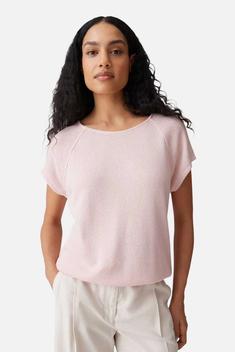 Top rose à manches courtes de OPUS, tricoté, encolure ronde et manches raglan, porté avec un pantalon clair.
