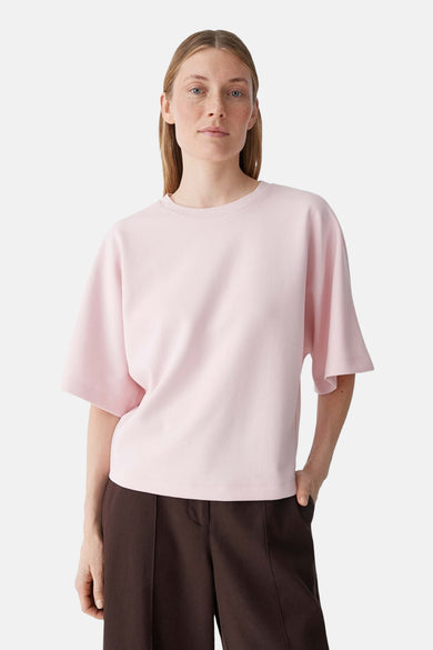 T-shirt rose d'OPUS à col rond et manches courtes évasées, porté avec un pantalon marron.
