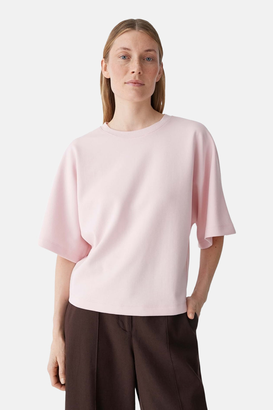 T-shirt rose d'OPUS à col rond et manches courtes évasées, porté avec un pantalon marron.