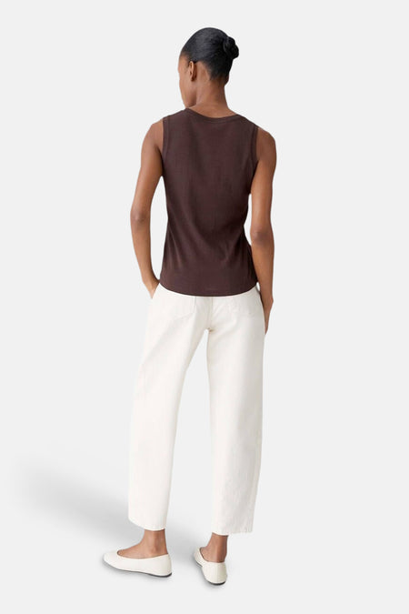 Top (sans manches) brun d'OPUS, porté avec un pantalon blanc taille haute et des ballerines blanches, vue de dos.