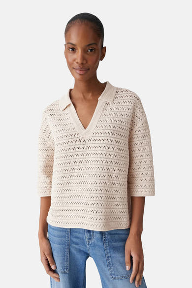 Pull à col en V écru par OPUS, en maille ajourée, porté avec un jean.