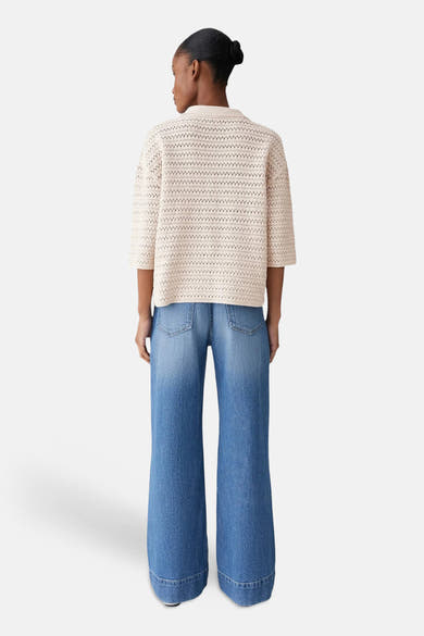 Pull col V vert de OPUS, porté avec un jean ample bleu délavé, vue de dos.
