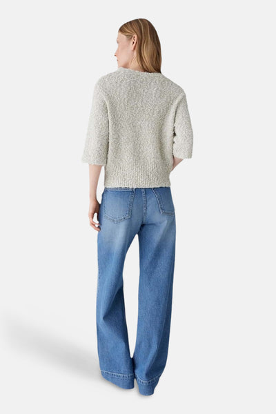Pull col rond beige d'OPUS, à manches trois-quarts, porté avec un jean taille haute ample.