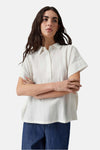 Yellow sleeveless blouse with button-down front and relaxed fit, worn with dark denim pants, front view.