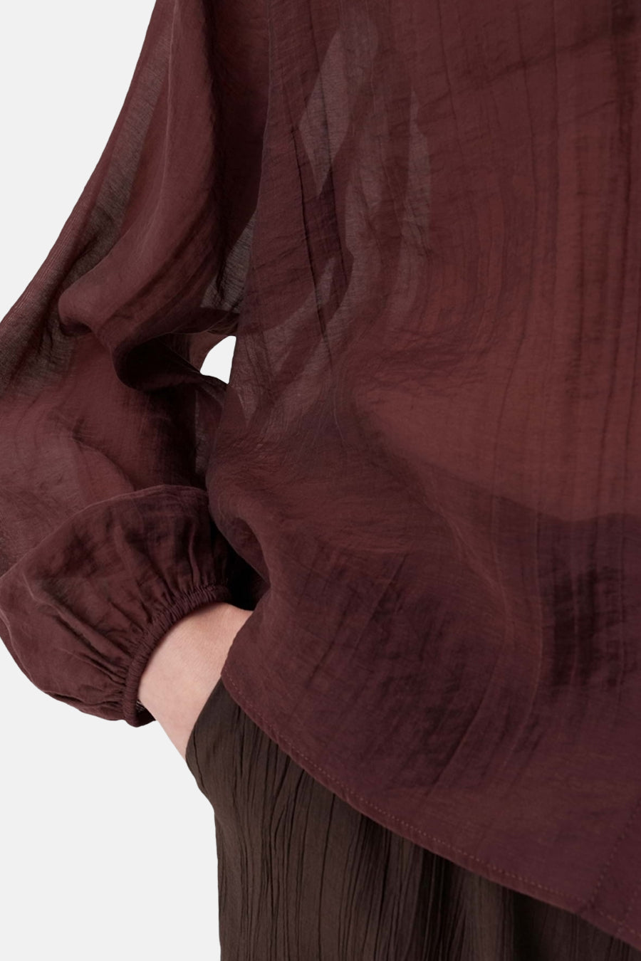 Bordeaux long-sleeve blouse with gathered cuffs and crinkled texture, side view close-up