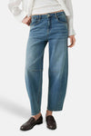 Jean mid blue en denim de coupe ample par OPUS, avec poches avant et ourlet droit, porté avec chemise blanche et mocassins marron.