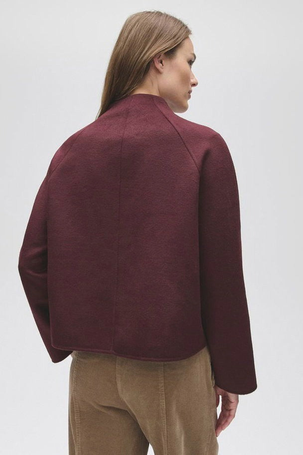 Veste bordeaux OPUS vue de dos, portée par une femme.