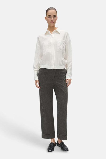 Blouse écrue OPUS à manches longues, col chemise et poches, portée avec un pantalon sombre.