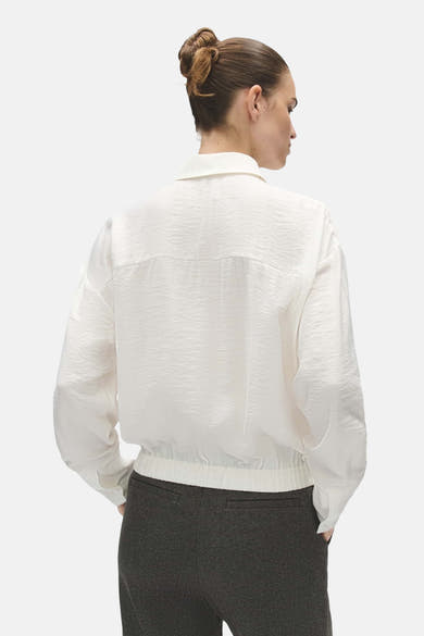 Blouse écrue à manches longues OPUS, vue de dos, portée avec un pantalon foncé.