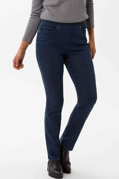 Jean denim bleu foncé de RAPHAELA, porté avec un pull gris et des bottines noires.
