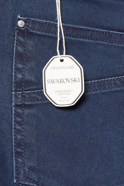 Jean bleu foncé de RAPHAELA, avec étiquette de la marque Swarovski sur la poche arrière.