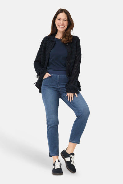 Jean slim bleu denim moyen de RAPHAELA avec une taille élastique confortable, porté par une femme.