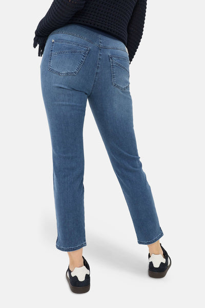 Jean slim bleu moyen en denim de RAPHAELA, vue arrière avec taille élastiquée, poches à surpiqûres et ourlets courts ornés de clous.