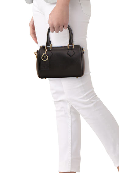 Sac à main noir d'Access® en cuir grainé avec anse courte et quincaillerie dorée, porté à la main.