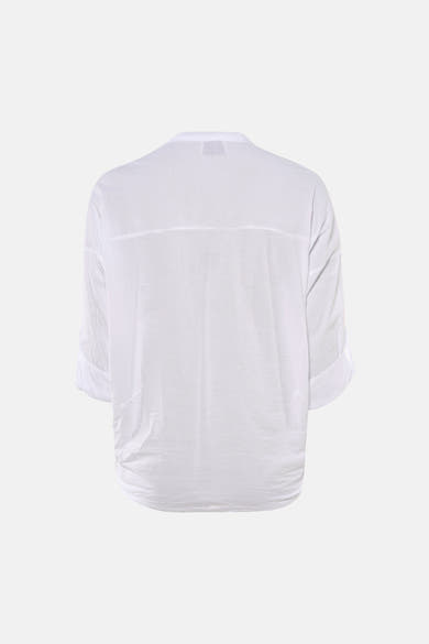 Blouse blanche à manches longues de Terra di Siena, avec ourlet retroussé et coupe ample.