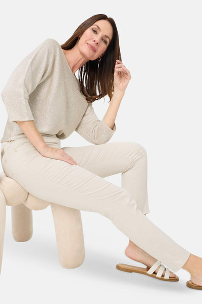 Beige slim-fit jeans by PAMINA 68, worn with a textured knit top and strappy sandals, shown in lifestyle pose.