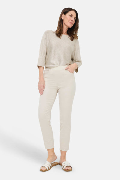 Beige slim-fit jeans by PAMINA 68, high-waisted with clean front pockets, shown on model in full-length lifestyle view with neutral top and sandals.