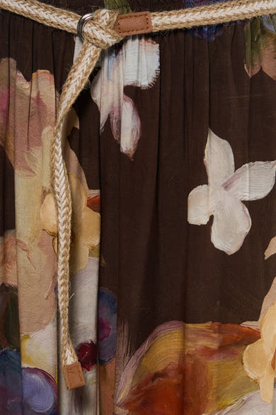 Brown floral print women's elastic waist pants with woven rope tie and leather accents, close-up front view