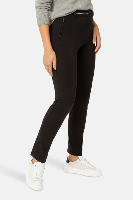 Zwarte broek van RAPHAELA, gedragen met een grijze trui en witte sneakers, zijwaarts gezien.