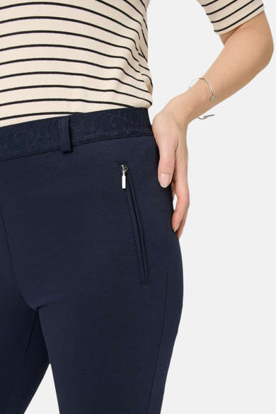 Pantalon de costume bleu marine par RAPHAELA, avec ceinture à motif et poche zippée.