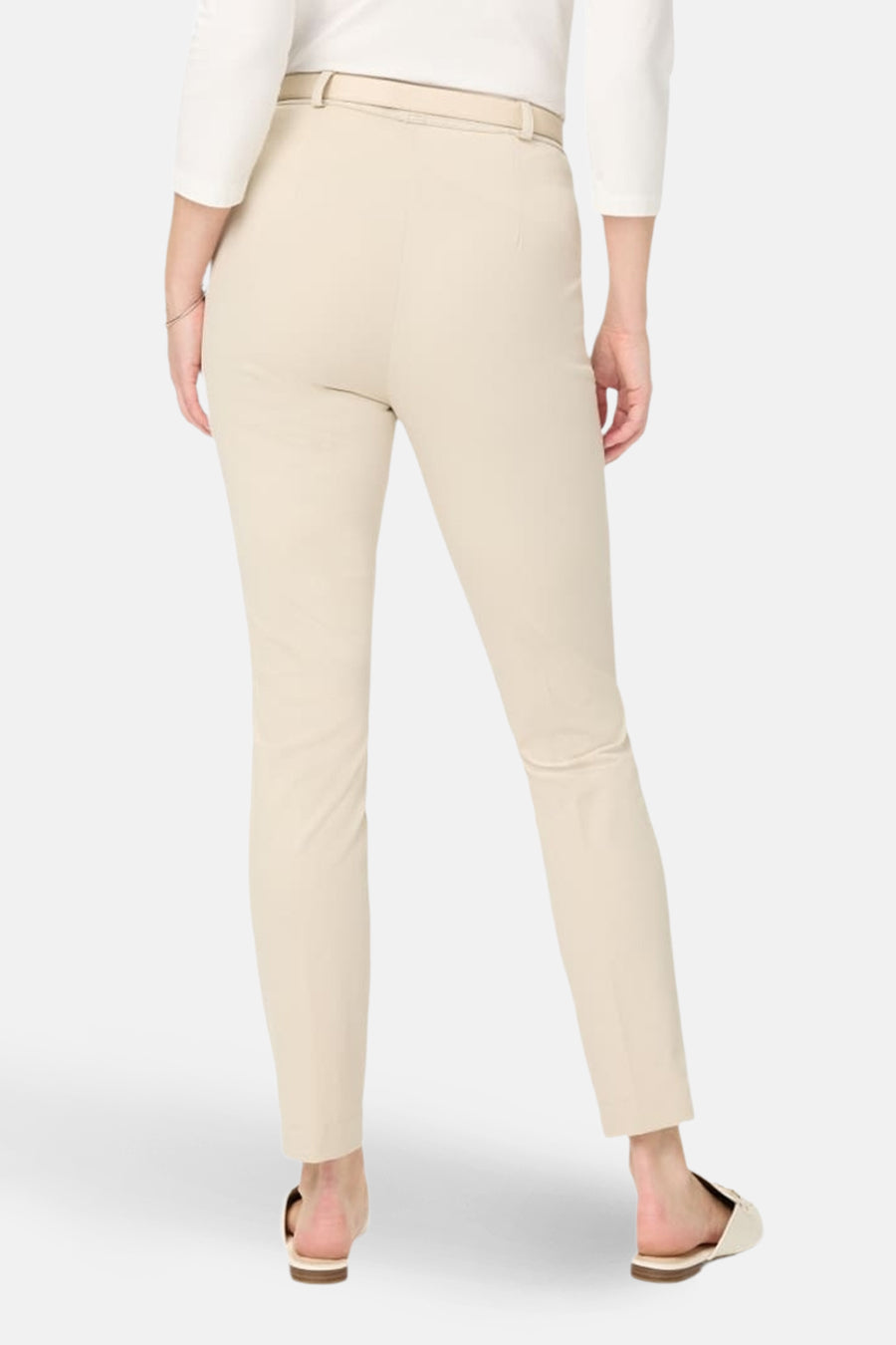 Pantalon de costume écru de RAPHAELA, coupe ajustée, avec ceinture ton sur ton et chaussures plates.
