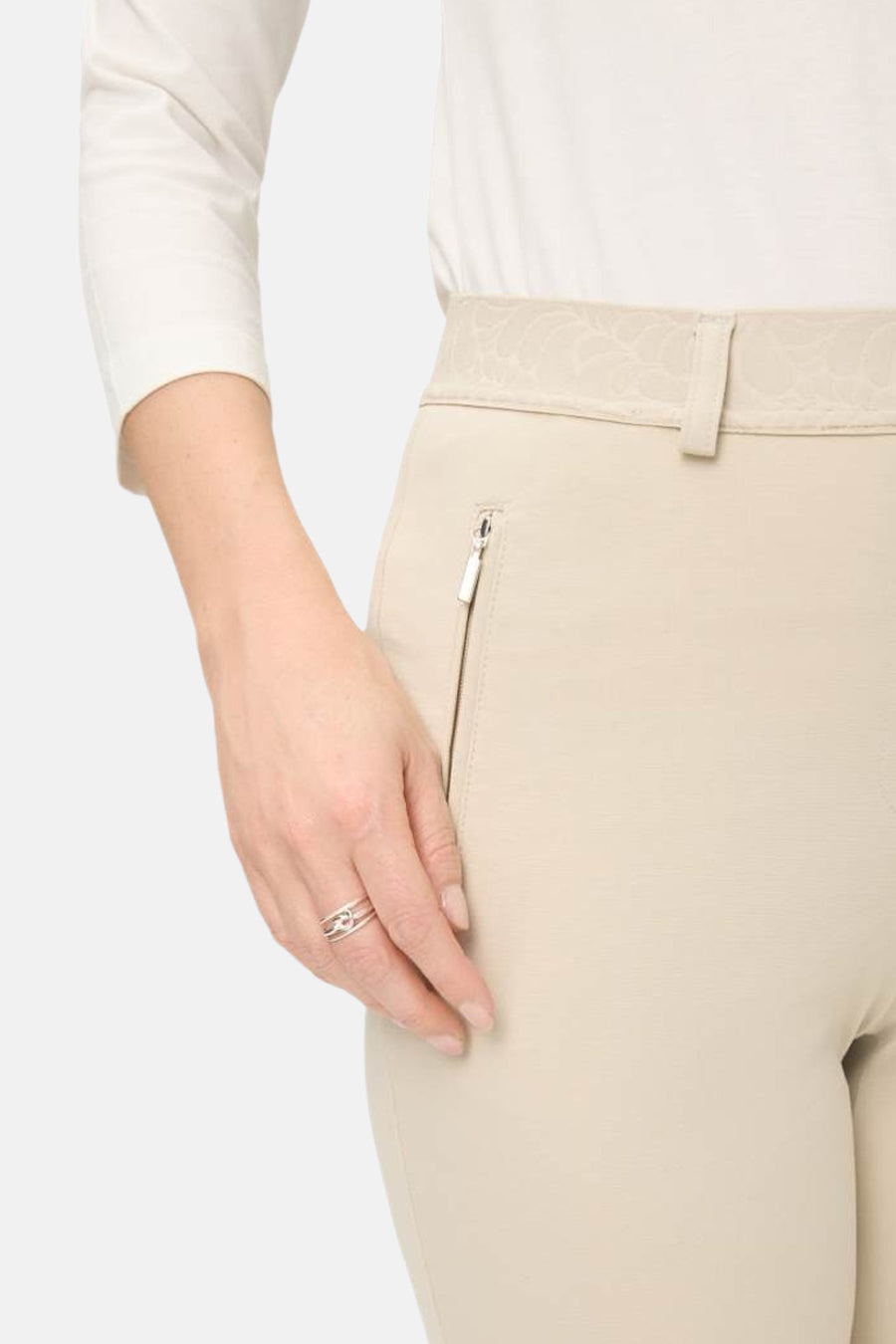 Pantalon de costume écru de Raphaela, avec motif sur la ceinture et poche zippée sur le côté.
