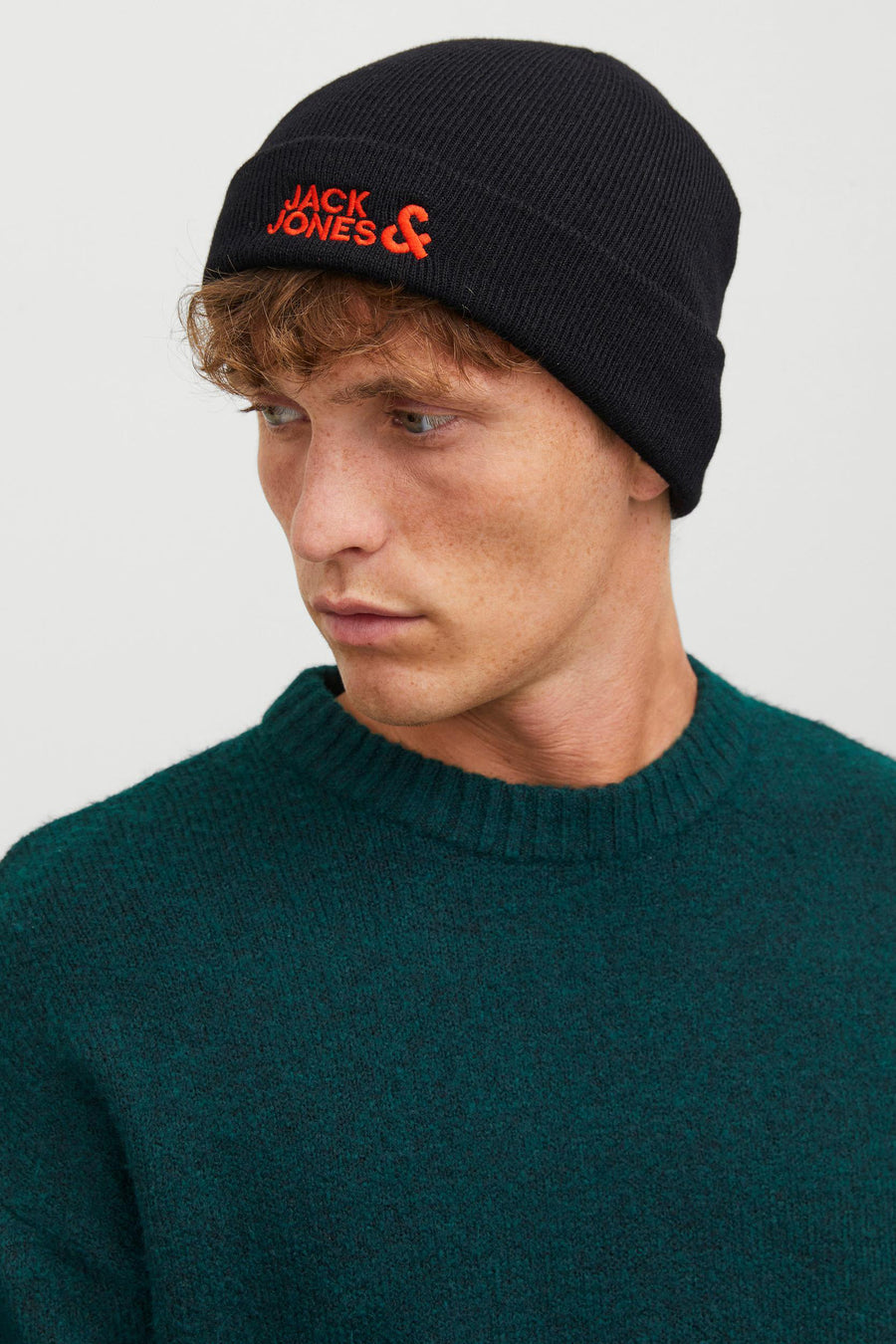 Bonnet noir ACCESSORIES BY JACK & JONES, porté avec un pull en maille vert foncé.