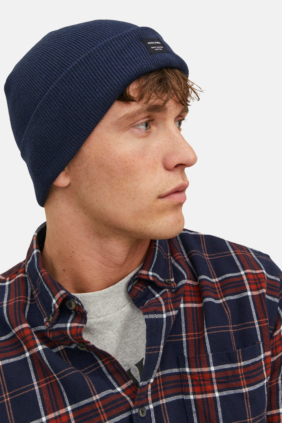Bonnet bleu marine par ACCESSORIES BY JACK & JONES, porté par un homme avec une chemise à carreaux.
