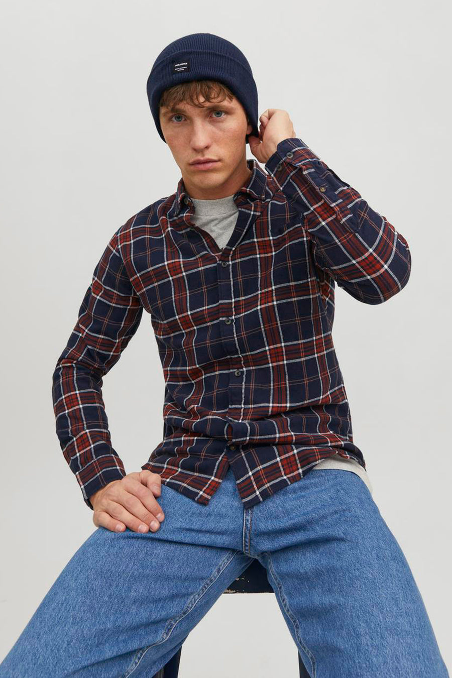 Bonnet bleu marine d'ACCESSORIES BY JACK & JONES, porté avec une chemise à carreaux et un t-shirt gris.
