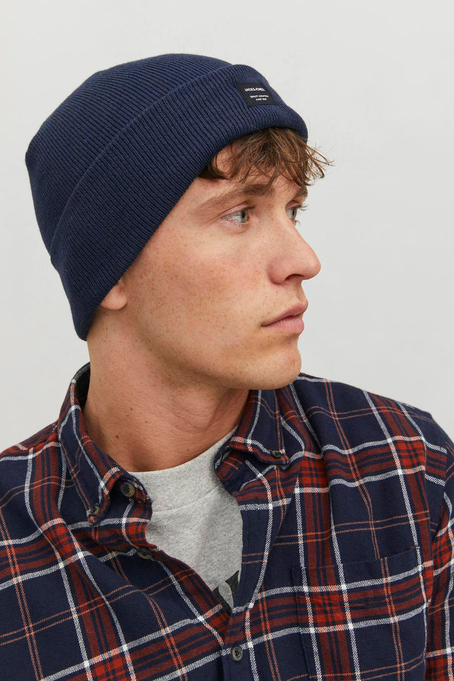 Bonnet bleu ACCESSORIES BY JACK & JONES, en maille côtelée, porté avec une chemise à carreaux.