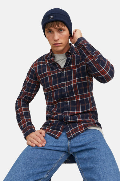 Bonnet bleu par ACCESSORIES BY JACK & JONES, porté avec une chemise à carreaux rouge et bleu marine et un jean.