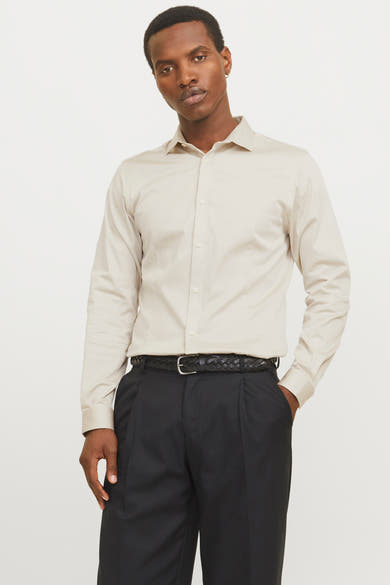 Ecru overhemd met lange mouwen van PREMIUM by JACK & JONES, gedragen met een zwarte broek en een gevlochten riem.