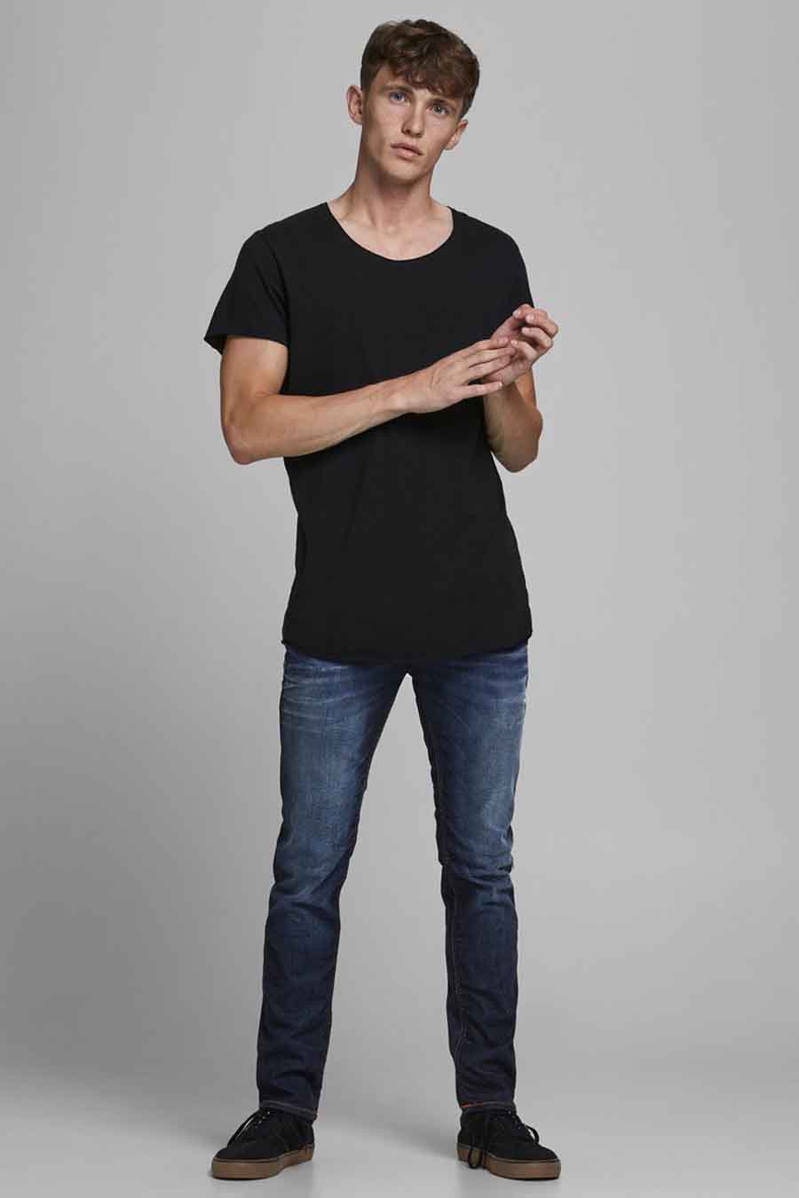 Slim fit donkerblauwe jeans van JACK & JONES JEANS INTELLIGENCE gedragen met een zwart T-shirt en zwarte sneakers.
