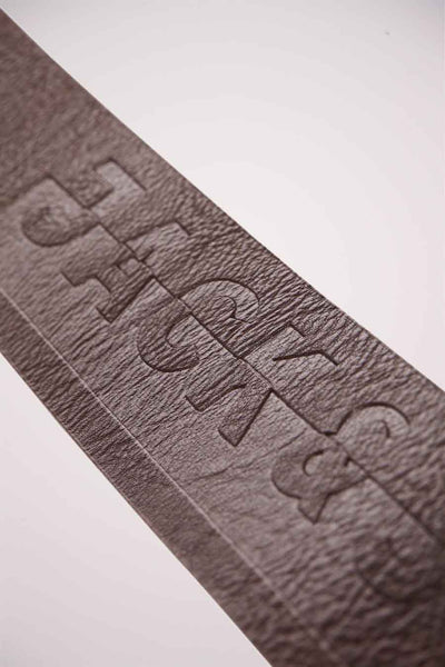 Bruine leren riem van ACCESSORIES BY JACK & JONES met reliëfopschrift en generfde textuur.