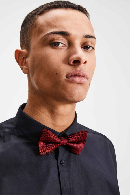 Nœud papillon brun de ACCESSORIES BY JACK & JONES, à motif texturé, porté avec une chemise noire boutonnée.