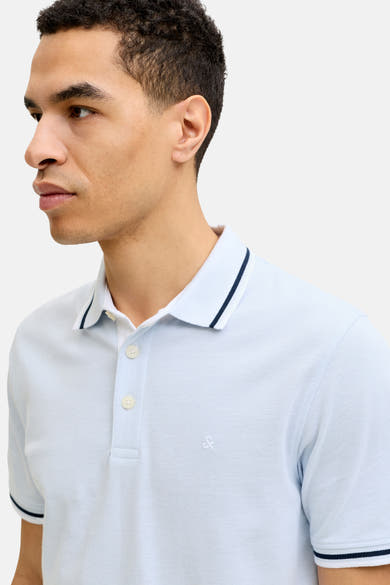 Polo bleu à manches courtes de PREMIUM by JACK & JONES, avec bordure marine au col et aux manches.