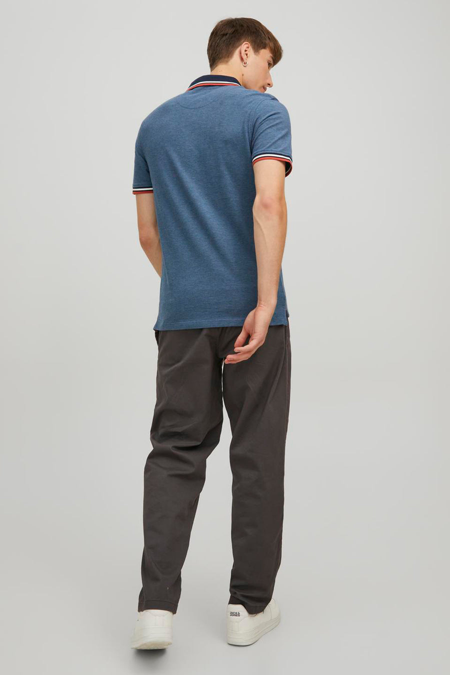 Gemêleerd blauw poloshirt van PREMIUM by JACK & JONES, met gestreepte details op de mouwen en kraag, gedragen met een casual broek.