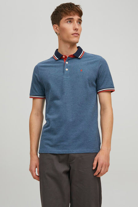 Polo bleu chiné by PREMIUM by JACK & JONES, avec détails rayés au col et aux manches, porté avec un pantalon gris anthracite.