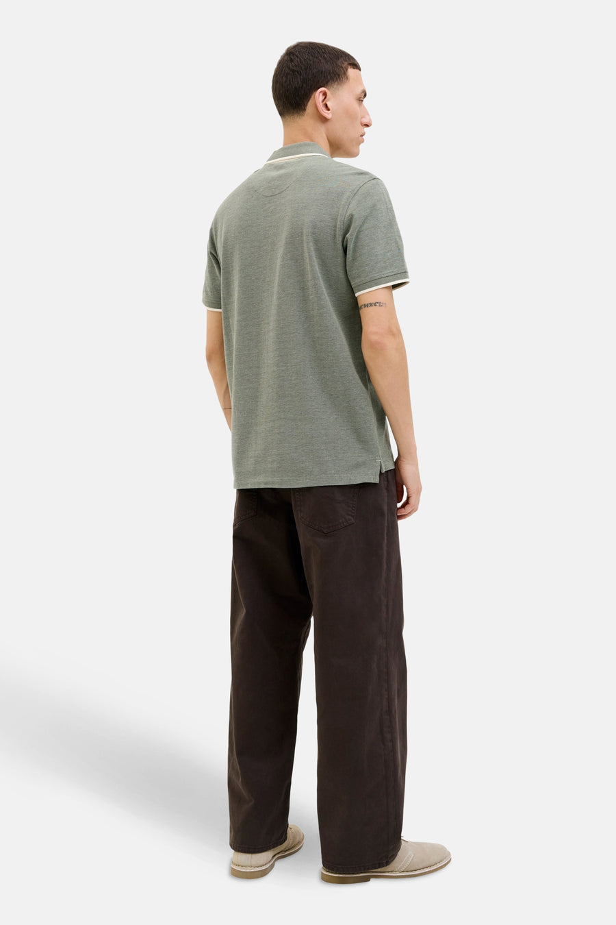Polo vert à manches courtes par PREMIUM by JACK & JONES, avec bordures blanches contrastantes, porté avec un pantalon marron.