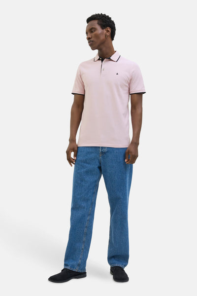 Polo rose à manches courtes de PREMIUM by JACK & JONES, porté avec un jean bleu et des chaussures noires.