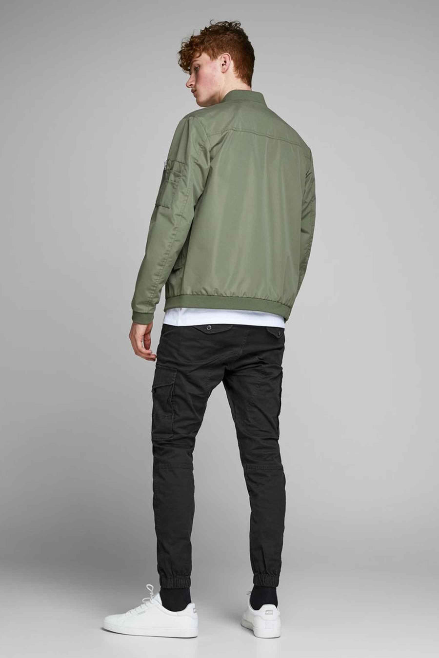 Pantalon cargo noir de JACK & JONES JEANS INTELLIGENCE, porté avec une veste kaki et des chaussures blanches.