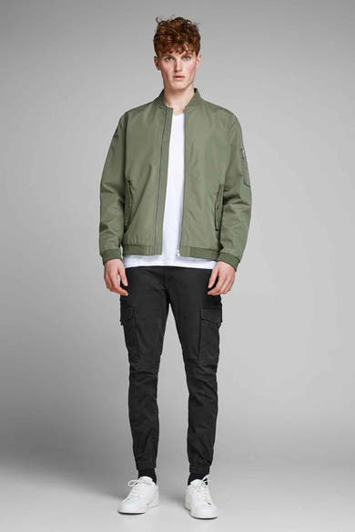 Pantalon cargo noir de JACK & JONES, porté avec une veste bomber kaki et des baskets blanches.