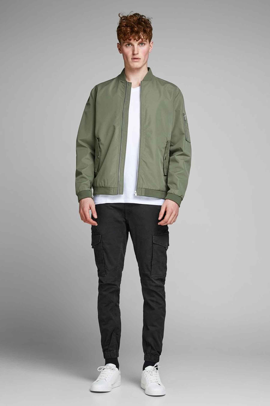 Pantalon cargo noir de JACK & JONES, porté avec une veste bomber kaki et des baskets blanches.