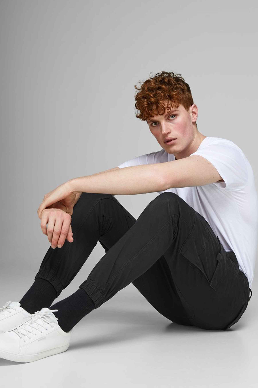 Pantalon cargo noir par JACK & JONES JEANS INTELLIGENCE, porté avec un t-shirt blanc et des baskets blanches.