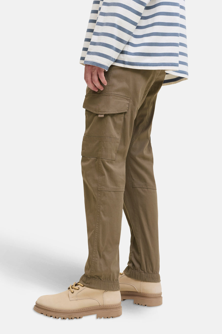 Pantalon cargo marron de JACK & JONES JEANS INTELLIGENCE, avec poches et ourlets élastiqués, porté avec un t-shirt rayé et des chaussures en cuir clair.