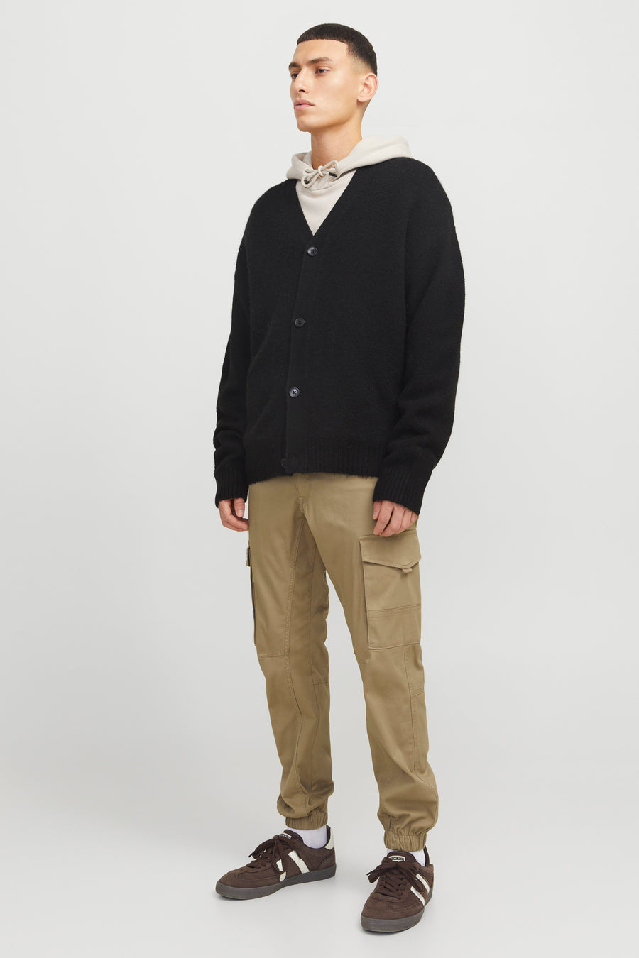 Pantalon cargo brun de JACK & JONES JEANS INTELLIGENCE porté avec un cardigan noir et des baskets marron.