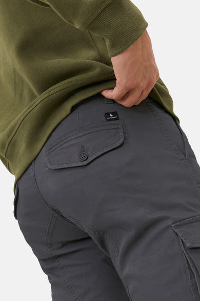 Chino gris par JACK & JONES, avec poche à rabat boutonnée, porté avec un pull vert olive.