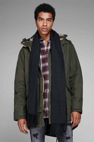 Écharpe noire à franges, de ACCESSORIES BY JACK & JONES, portée avec une chemise à carreaux et une parka kaki.