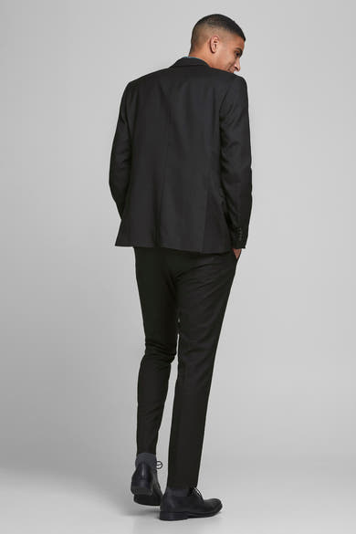 Blazer noir de PREMIUM par JACK & JONES, homme vu de dos portant un pantalon de costume et des chaussures en cuir noires.